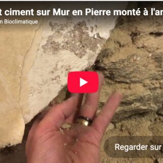 Enduit ciment qui se décolle d'un mur ancien en pierre